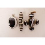 A white metal mounted agate eye pendant, a metal set banded agate five stone pendant and an agate