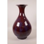 A Chinese flambé glazed pottery pear shaped vase with a flared rim, 13½" high