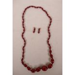 A cherry amber graduated beaded necklace and matching pair of drop earrings, with gold mounts,