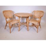 A rattan conservatory suite of a table and two chairs