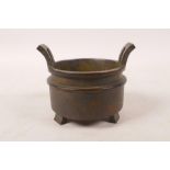 A Chinese bronze two handled censer, impressed character marks to base, 3½" diameter