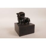 A Chinese square form filled bronze seal with a temple lion surmount, 4" x 4" x 5"