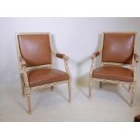 A pair of French style painted open armchairs, with brass studded leatherette covers, raised on