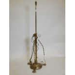 A brass adjustable standard lamp, raised on three claw feet, 54" feet
