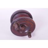 A vintage English made wooden fishing reel with brass foot, 2½" diameter