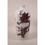 A Chinese red and white porcelain vase decorated with a dragon chasing the flaming pearl, 12½" high