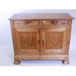 A C19th French cherrywood buffet, with two drawers over two cupboards, raised on ogee shaped