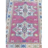A Middle Eastern hand knotted wool carpet with star patterns on a terracotta field, 50" x 70"