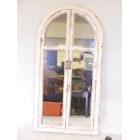 A painted and distressed arch topped wall mirror, 29½" x 57"