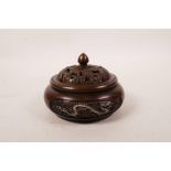 A Chinese bronze censer and cover with raised and silvered dragon and phoenix decoration,