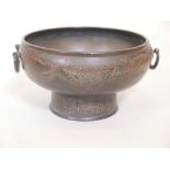 A Meiji bronze footed bowl with two handles and engraved phoenix decoration, inscribed to base,