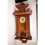 A C19th walnut cased Vienna regulator wall clock with floral embossed gilt dial and ceramic