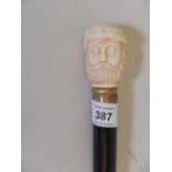 A hardwood walking cane with brass mounts and bone handle, carved as a bearded Ottoman gentleman,