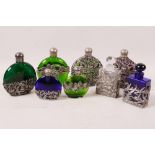 A collection of eight Art Nouveau style pewter cased perfume bottles, various coloured glass,
