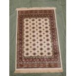 An ivory Kashmir rug, with a traditional Bokhara design, 45½" x 67"
