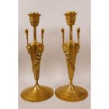 A pair of ormolu Empire style candlesticks decorated with swags and flowers, with Bacchus head