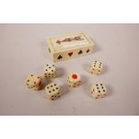 A set of six faux bone dice in a bone case with playing card decoration, 3½" x 2"