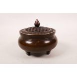 A Chinese bronze censer and cover on tripod supports, the cover with woven cane style decoration,