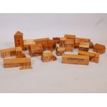 A quantity of wooden toy village houses and shops with painted decoration, church spire 9" high