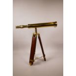 A brass telescope on an extendable wood and brass tripod stand, telescope 16½" long