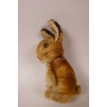 A 1952/53 Steiff begging rabbit, golden mohair, fixed limbs, brown and black glass eyes, red