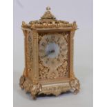 An ormolu mantel clock with Indian style pierced decoration, raised on elephant mask supports,