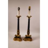 A pair of Regency style bronzed and brass table lamps, raised on paw feet, 21" high