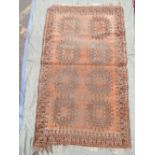 A Turkish rust ground wool rug decorated with a medallion pattern, 74" x 44"