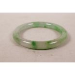 A mottled green jade bangle, 2½" diameter