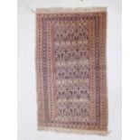 A Persian beige ground wool rug decorated with a boteh pattern, 61" x 37"