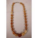 An amber graduated bead necklace with lighter coloured feature beads, 26" long