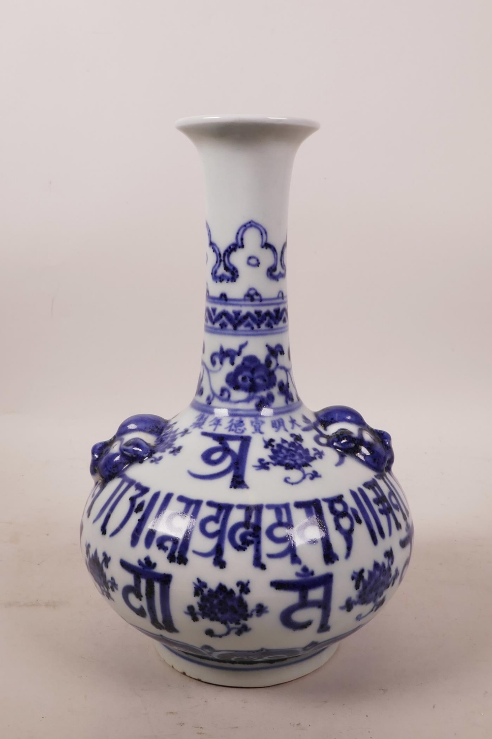 A Chinese blue and white porcelain vase with two mask handles and decorative inscription, 9" high