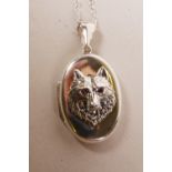 A 925 silver locket and chain, the cover decorated with a wolf with ruby set eyes, 1"