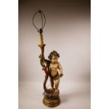 A carved wood lamp in the form of a cherub with polychrome paint and early C20th parcel gilt