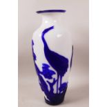 A blue and white cased Peking glass vase decorated with cranes and flowering trees, 12" high