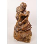 An art pottery figurine of a lovers' embrace mounted on a wooden plinth, 13½" high