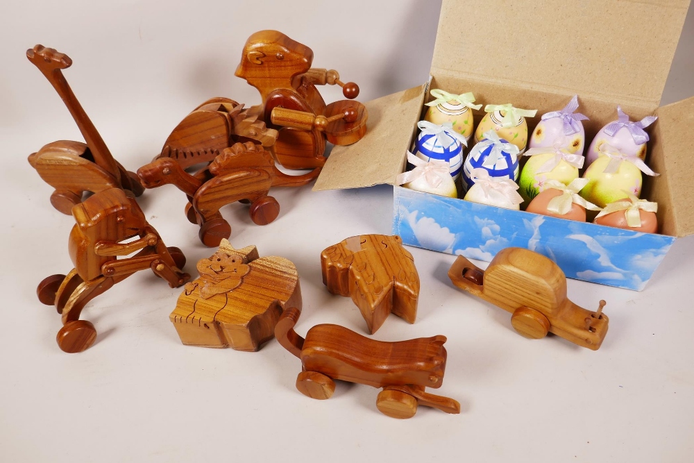 A quantity of animated wooden toys, two puzzle trinket boxes and a box of painted eggs with surprise