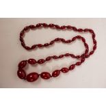 A cherry amber graduated bead necklace, 30" long, and a pair of gold set drop earrings