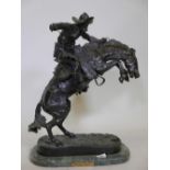 After Frederic Remington, 'Bronco Buster', patinated bronze figure of a cowboy, impressed with