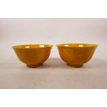A pair of Chinese ochre ground porcelain rice bowls with underglaze dragon decoration, 6 character