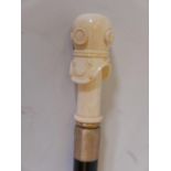 A hardwood walking cane with brass mounts and bone handle carved in the form of a diver's helmet,