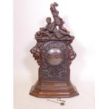 A C19th Black Forest walnut bracket clock, with carved decoration of oak and acorns under a figure
