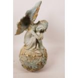 A cast iron garden figurine of a fairy seated on a flower, 12½" high