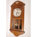 A 1930s oak cased wall clock with silvered dial and black Arabic numerals, striking movement and