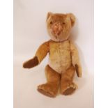 A large plush teddy bear with glass eyes and corduroy paws, circa 1940, 26" long, A/F
