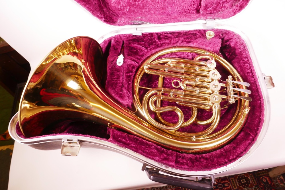 A brass French horn in fitted case