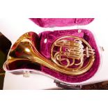 A brass French horn in fitted case