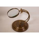 A brass framed desktop magnifying glass, lens 5" diameter