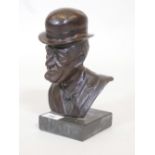 A bronze bust of a gentleman in a bow tie and bowler hat, mounted on a marble base, unsigned, 9"