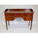 An early C19th mahogany sideboard, with three quarter galleried top and gadrooned edge over five